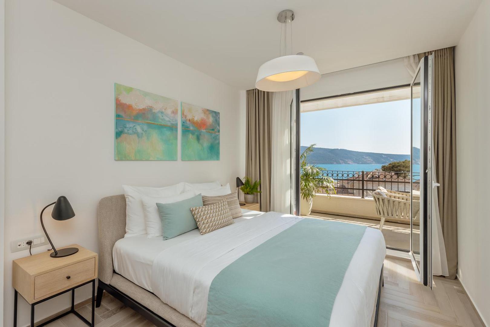 Gaišs Lazure Hotel & Marina numurs ar divguļamo gultu un atvērtām durvīm uz balkonu, no kura paveras skats uz jūru