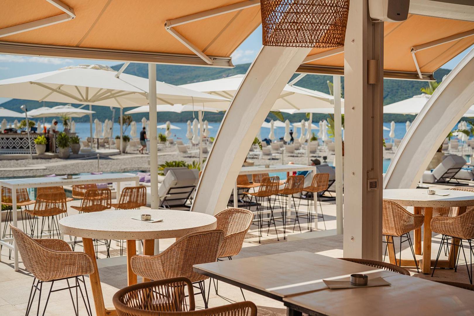Lazure Hotel & Marina pludmales bārs un atpūtas zona ar pītiem krēsliem un saulessargiem pie Adrijas jūras