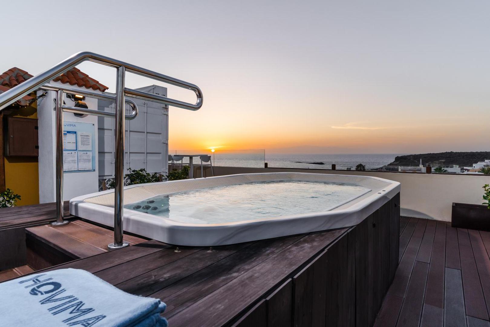 Hovima Jardin Caleta jumta terases džakuzi saulrieta laikā Tenerifē ar skatu uz okeānu un piekrastes panorāmu