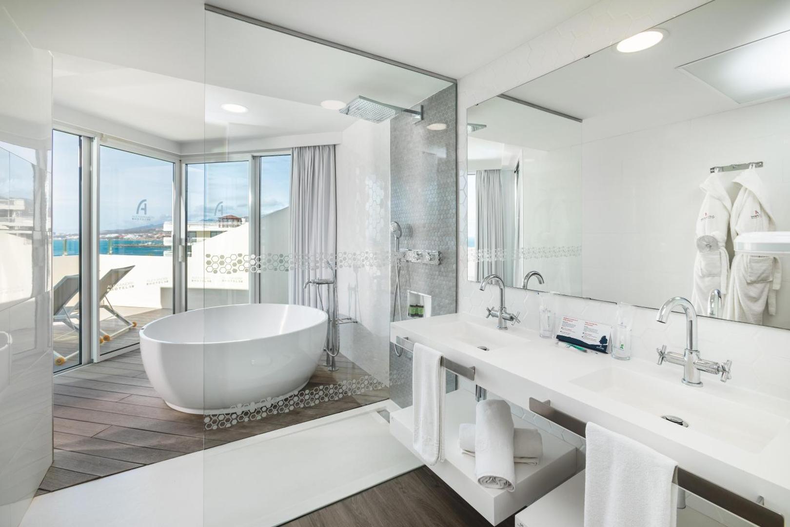 Alexandre Hotel Troya modernā vannas istaba Tenerifē ar brīvstāvošu vannu, dušu un skatu uz okeānu no privātā balkona