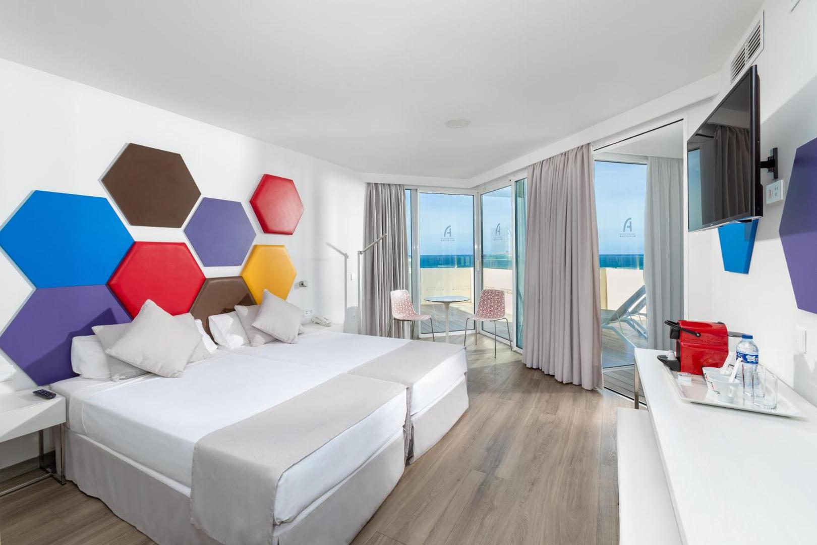 Alexandre Hotel Troya moderns numurs ar krāsainu sienas dekoru un balkonu, no kura paveras skats uz okeānu Tenerifē