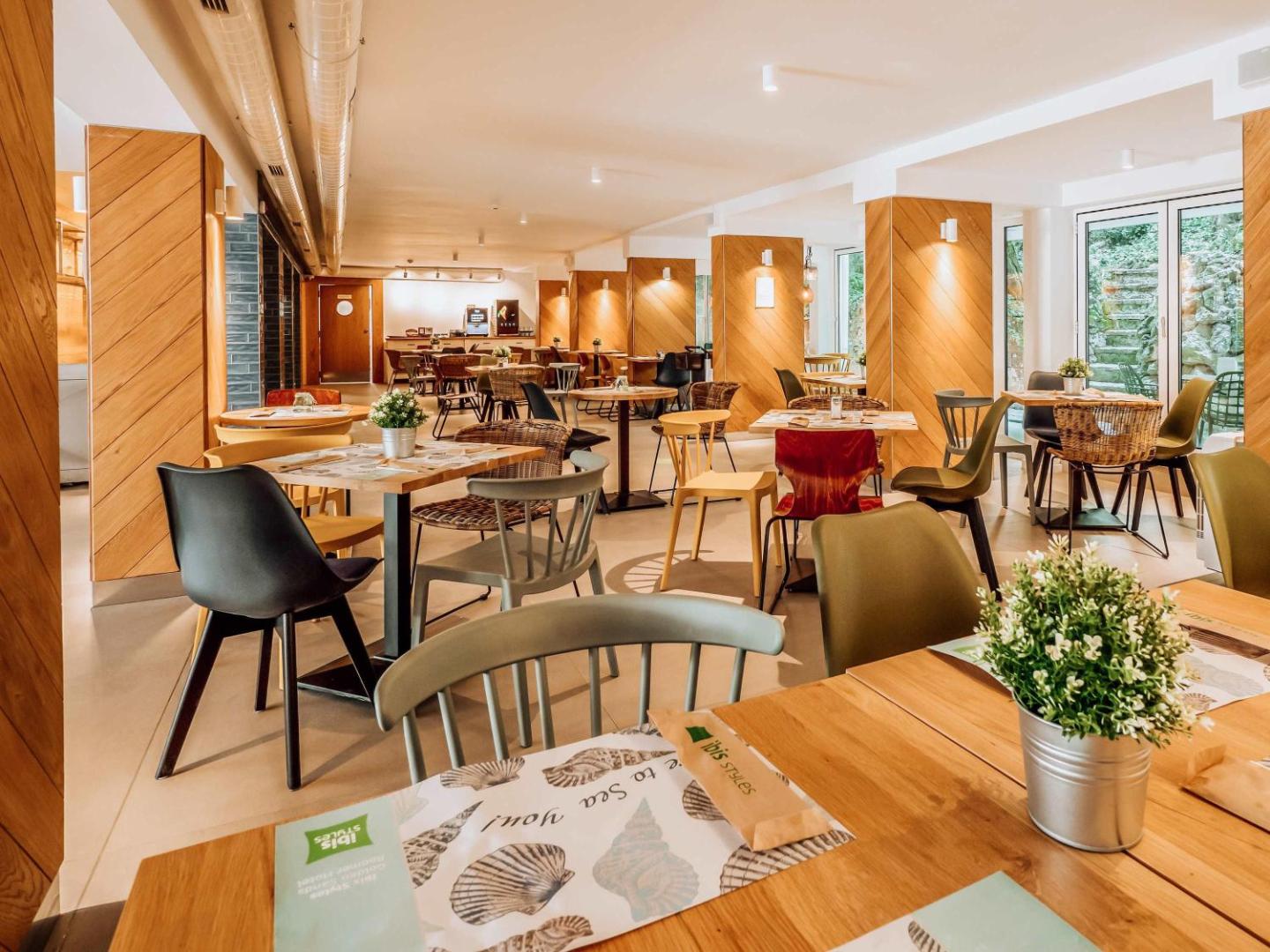 Ibis Styles Golden Sands Roomer Hotel modernais restorāns ar koka apdari, stilīgām mēbelēm un gaišu interjeru Bulgārijas kūrortā