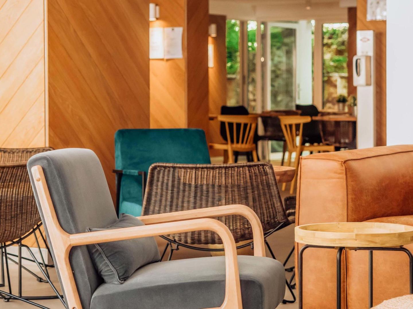 Ibis Styles Golden Sands Roomer Hotel lobby atpūtas zona ar ērtiem dizaina krēsliem un siltu koka apdari
