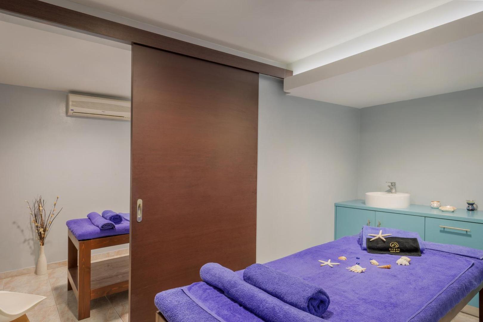 Viesnīcas Sol by Melia Cosmopolitan Rhodes spa zona ar diviem masāžas galdiem un koka bīdāmajām durvīm Rodas piekrastē.
