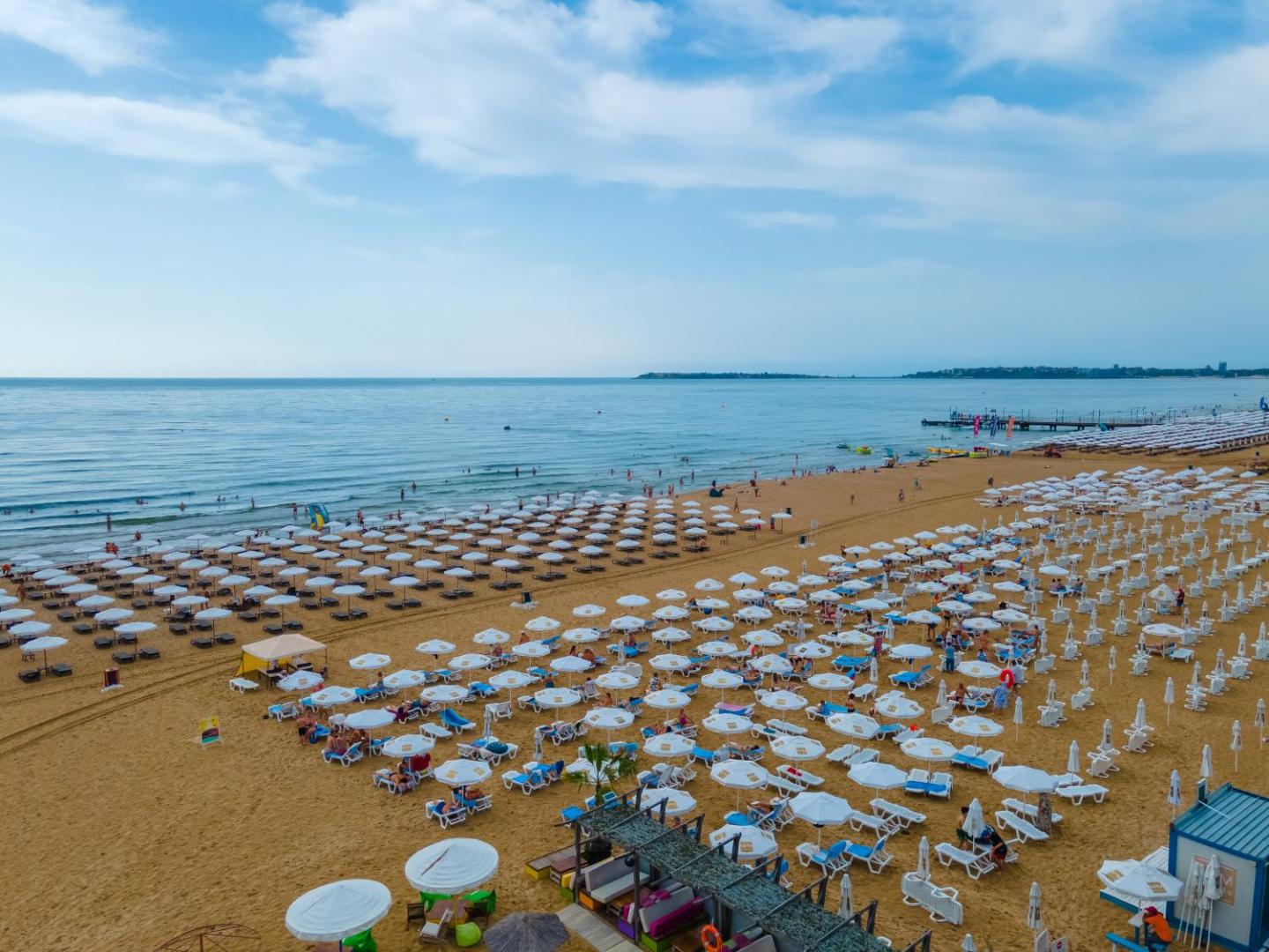 MPM Hotel Astoria plašā privātā pludmale Saulainajā Krastā, Bulgārijā — skats no augšas uz zelta smiltīm, neskaitāmiem saulessargiem un zilo jūru