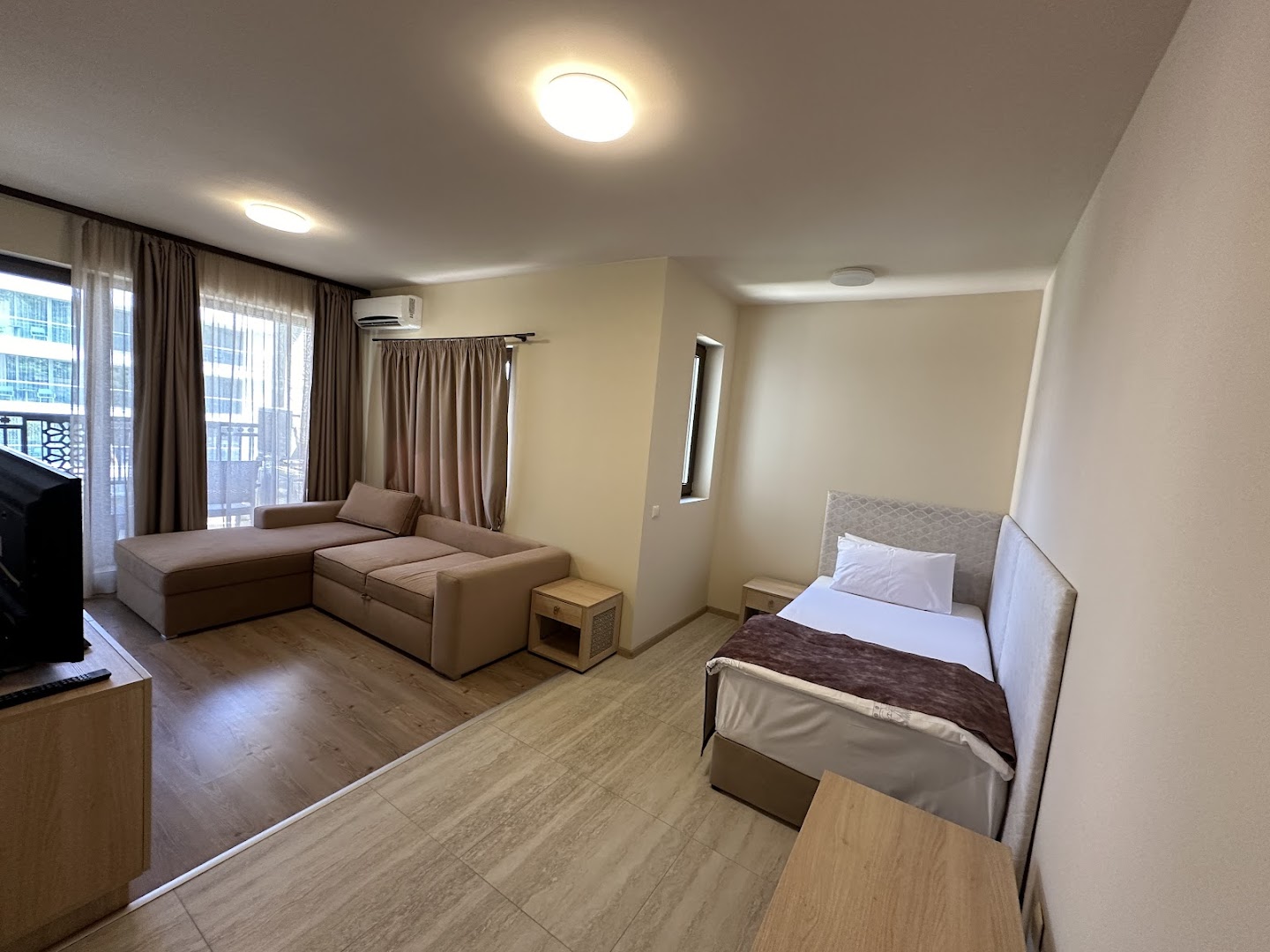 Argisht Partez Hotel plašs numurs ar atpūtas zonu, dīvānu un gultu Zelta Smiltīs, Bulgārijā — gaišs interjers ar balkona durvīm