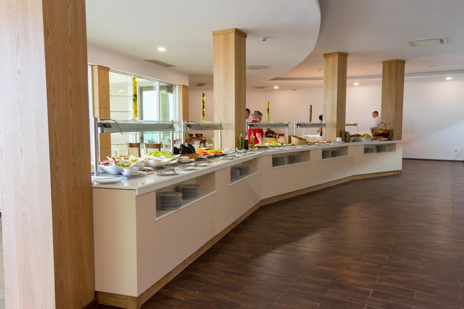 Bilyana Beach Hotel galvenā restorāna pašapkalpošanās līnija ar plašu ēdienu izvēli un modernu apgaismojumu