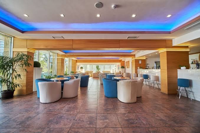 Plašs Bilyana Beach Hotel atpūtas salons ar krāsainu LED apgaismojumu griestos, bāra zonu un modernām mēbelēm