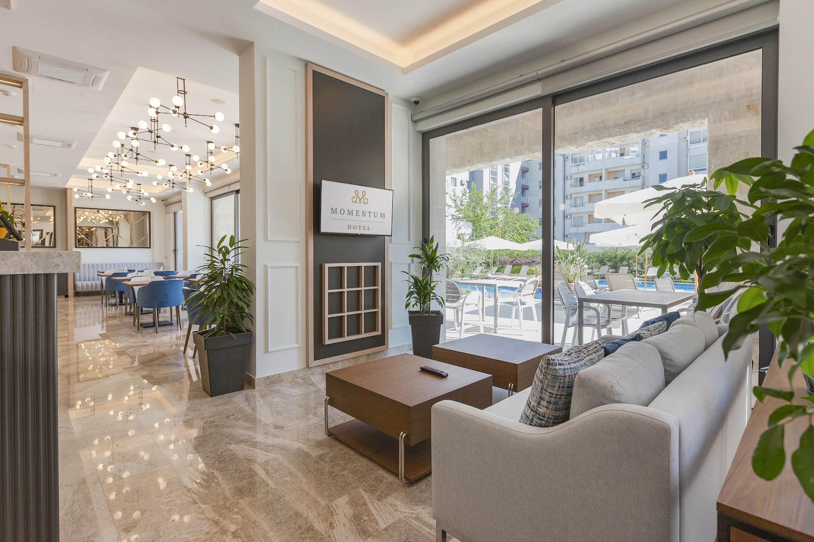 Momentum by Aycon Boutique Hotel lobby zona ar modernām mēbelēm, dizaina lampām un skatu uz baseina teritoriju