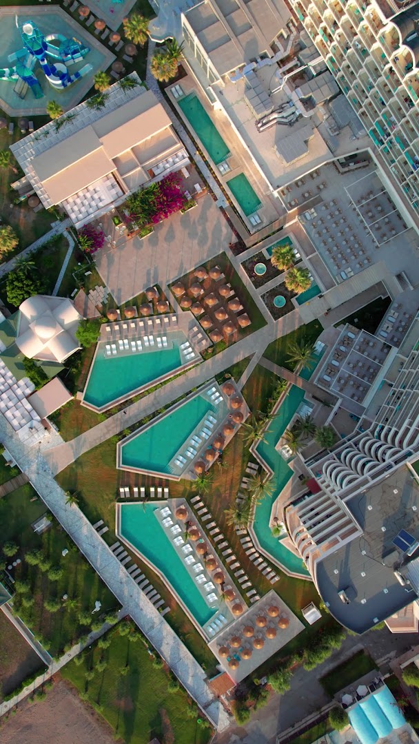 Pegasos Beach Hotel teritorijas skats no augšas, izceļot vairākus āra baseinus, atpūtas zonas ar sauļošanās krēsliem un bērnu akvaparka slidkalniņus.