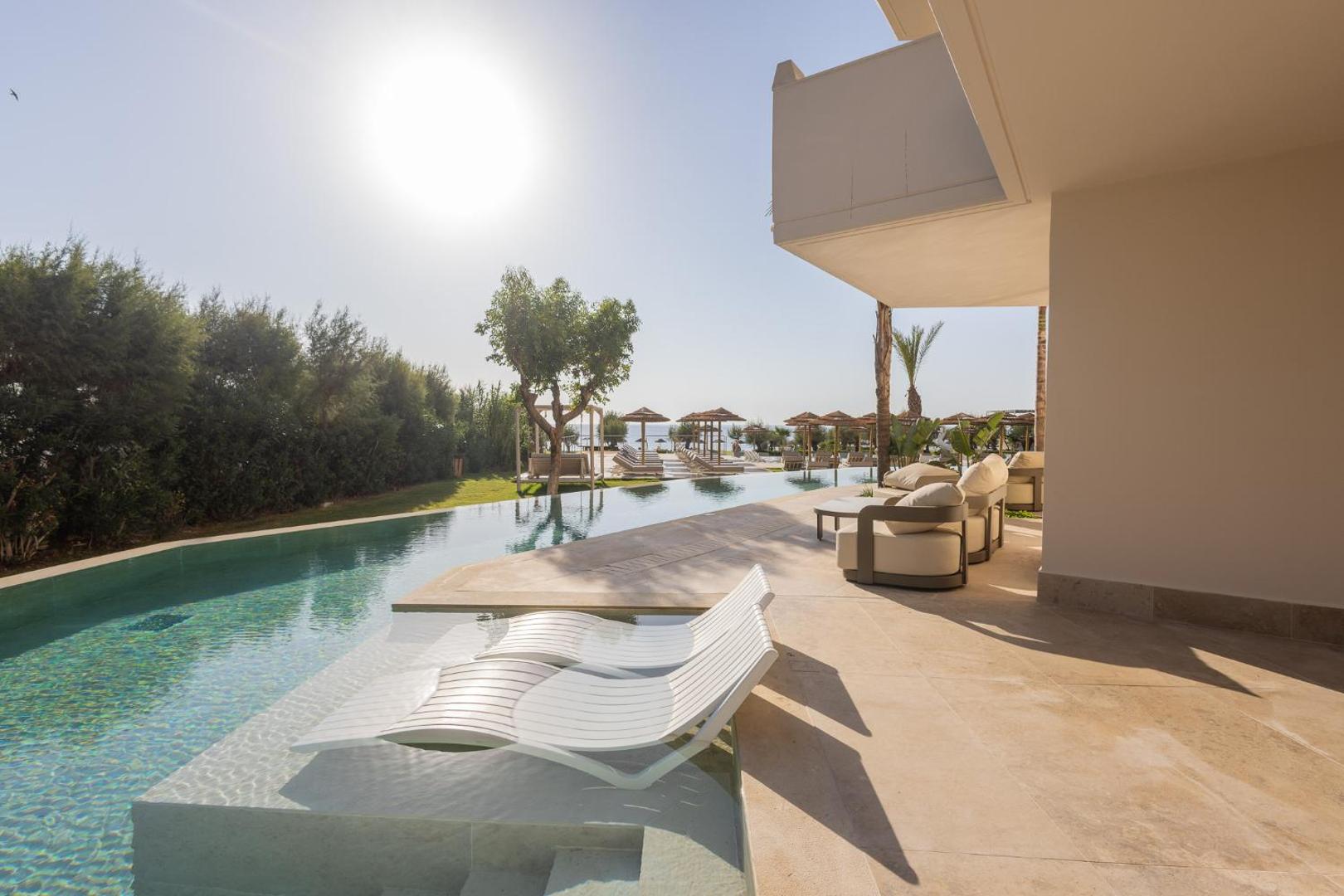 Pegasos Beach Hotel numurs ar tiešu piekļuvi baseinam — terase ar atpūtas krēsliem un skatu uz dārzu un jūru