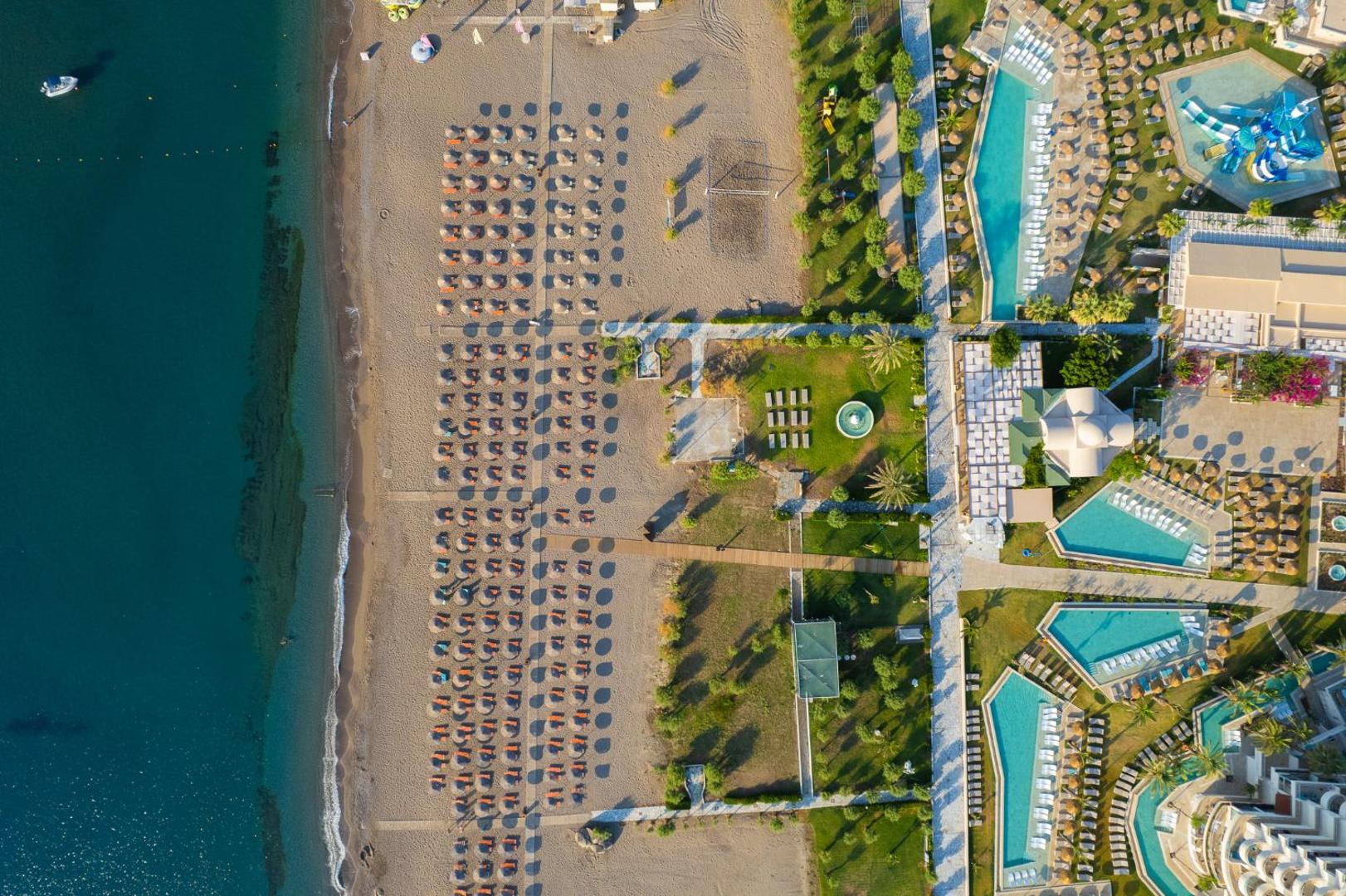 Pegasos Beach Hotel aero fotoattēls no augšas — plaša smilšu pludmale, saulessargi, vairāki baseini un akvaparks Rodā