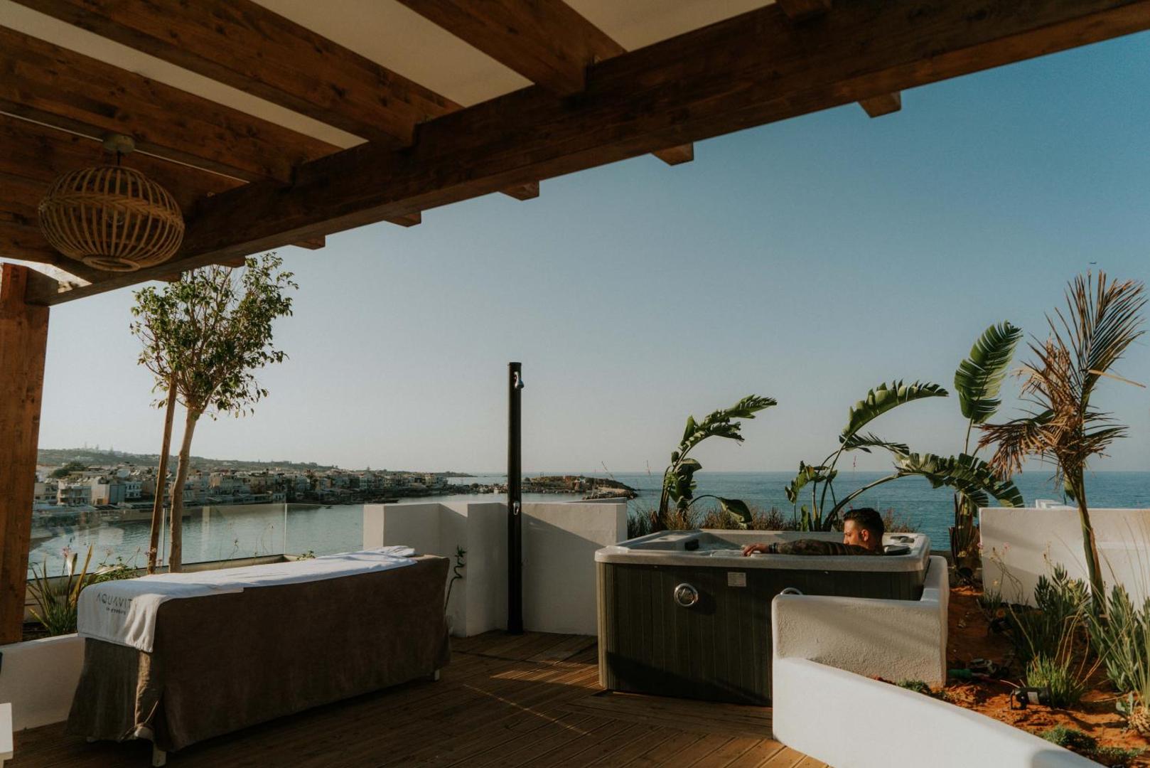 Kahlua Boutique Hotel āra terase ar džakuzi un masāžas galdu piekrastē — skats uz Hersonisas līci un Vidusjūru saulrietā