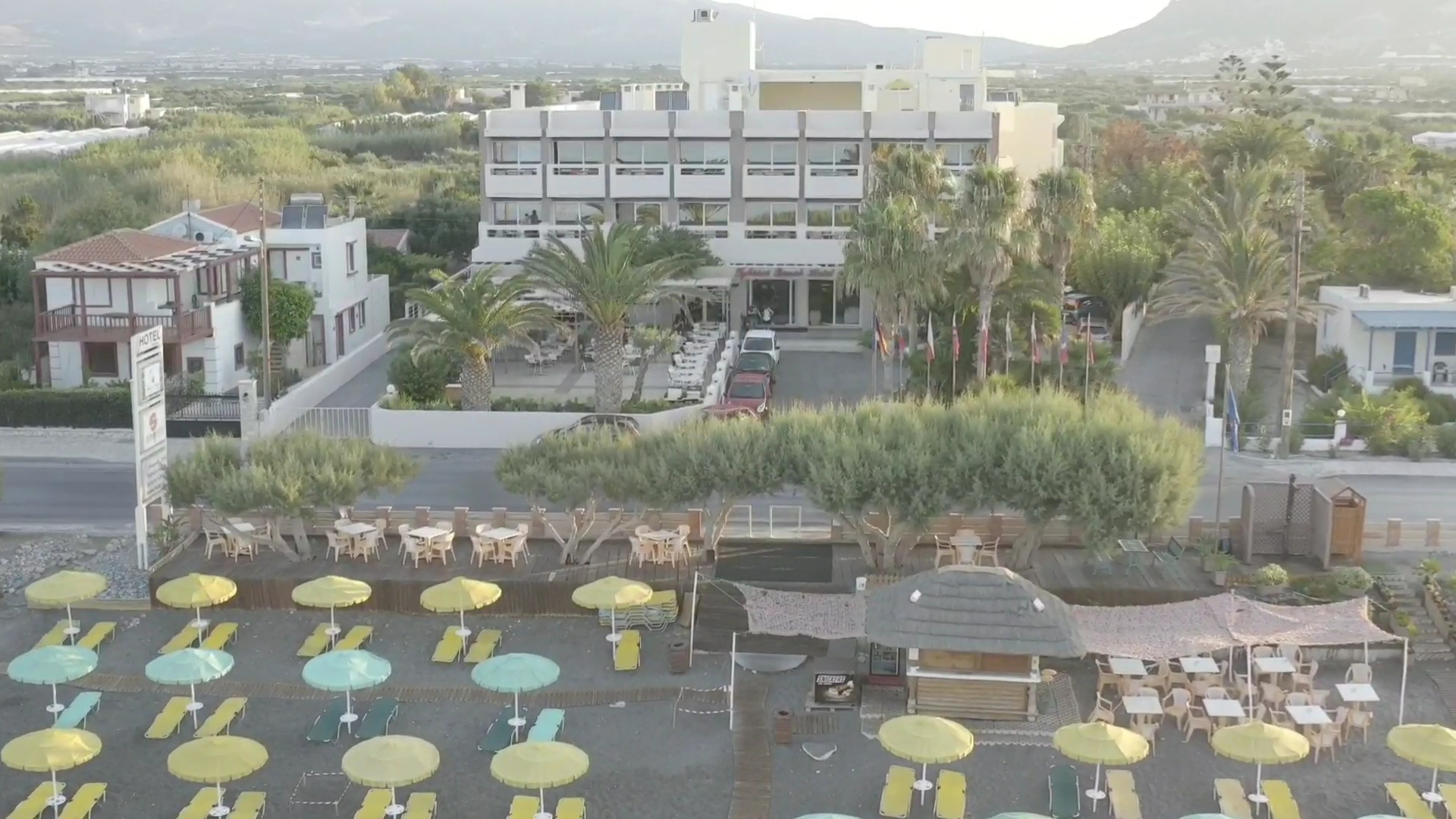 Tylissos Beach Hotel pludmales bārs un atpūtas zona ar dzelteniem saulessargiem pie jūras Krētas piekrastē