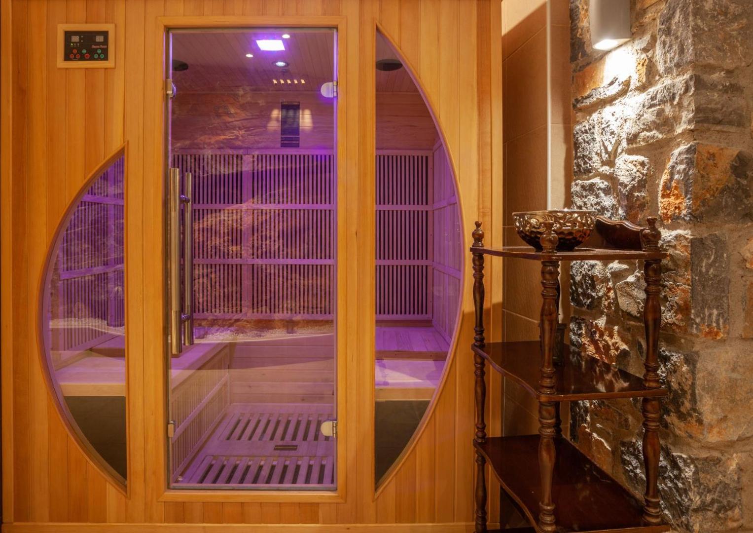 Elounda Waterpark Residence Hotel spa centra sauna ar koka apdari un modernu apgaismojumu relaksācijai pēc dienas pie baseina