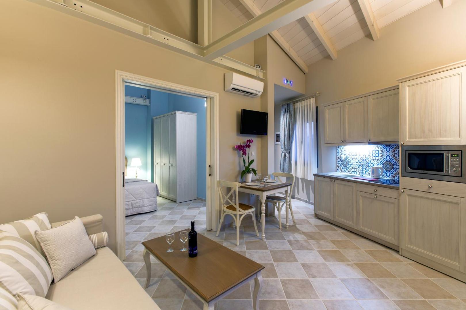 Ionia Suites stilīgs numurs ar augstiem griestiem un virtuvi Retimno — gaišas mēbeles un atsevišķa ieeja guļamistabā
