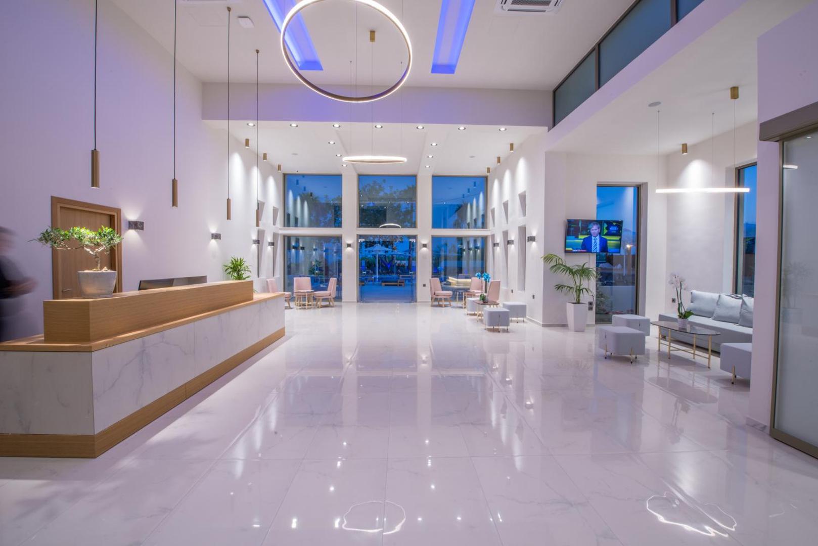 CHC Imperial Palace viesnīcas lobby zona ar marmora grīdu, modernu recepcijas galdiņu un augstiem griestiem — elegants interjers