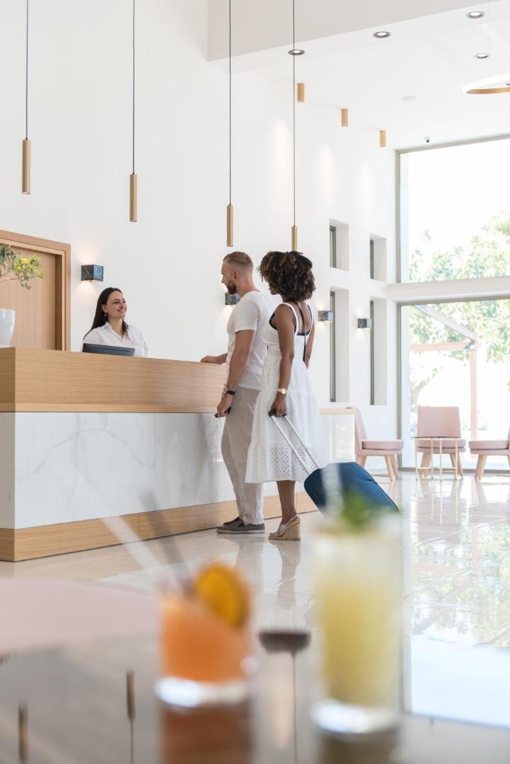 CHC Imperial Palace viesnīcas gaišā recepcijas zona ar koka un marmora apdari, kur viesus sagaida smaidīgs personāls