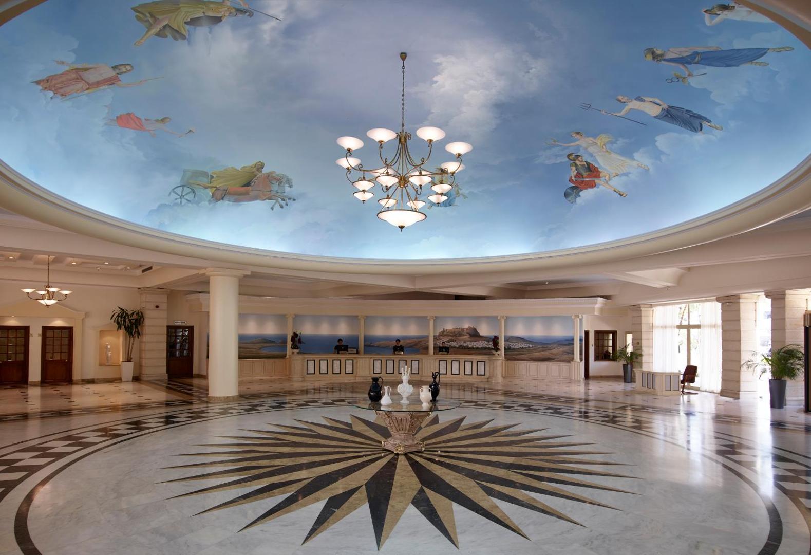 Lindos Princess Beach Hotel greznais vestibils ar apgleznotu kupola griestu fresku, kristāla lustru un marmora grīdu Rodā