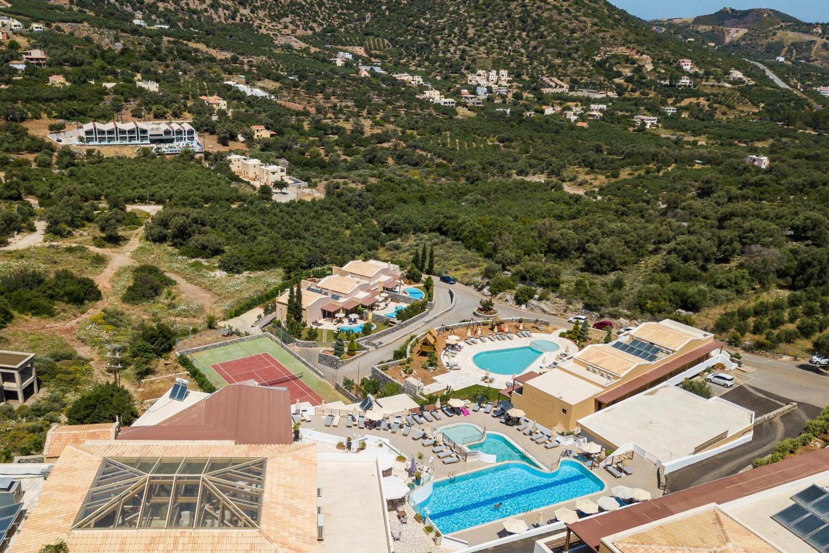 Filion Suites Resort & Spa viesnīcas komplekss Krētas kalnu ainavā ar baseiniem, saules terasēm un apkārtējiem olīvkokiem