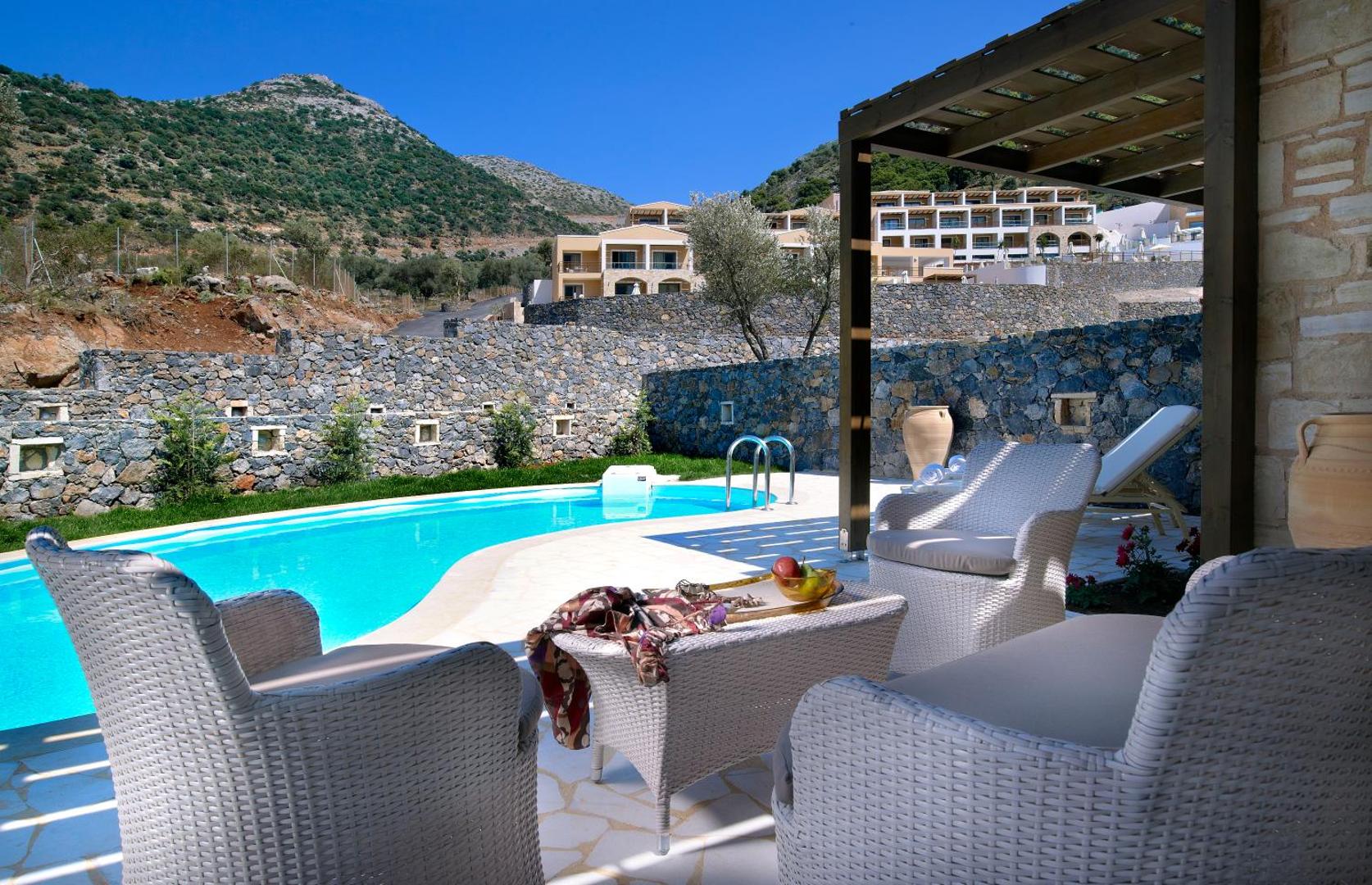 Filion Suites Resort & Spa numurs ar privātu baseinu un mēbelētu terasi — skats uz viesnīcas teritoriju un kalniem