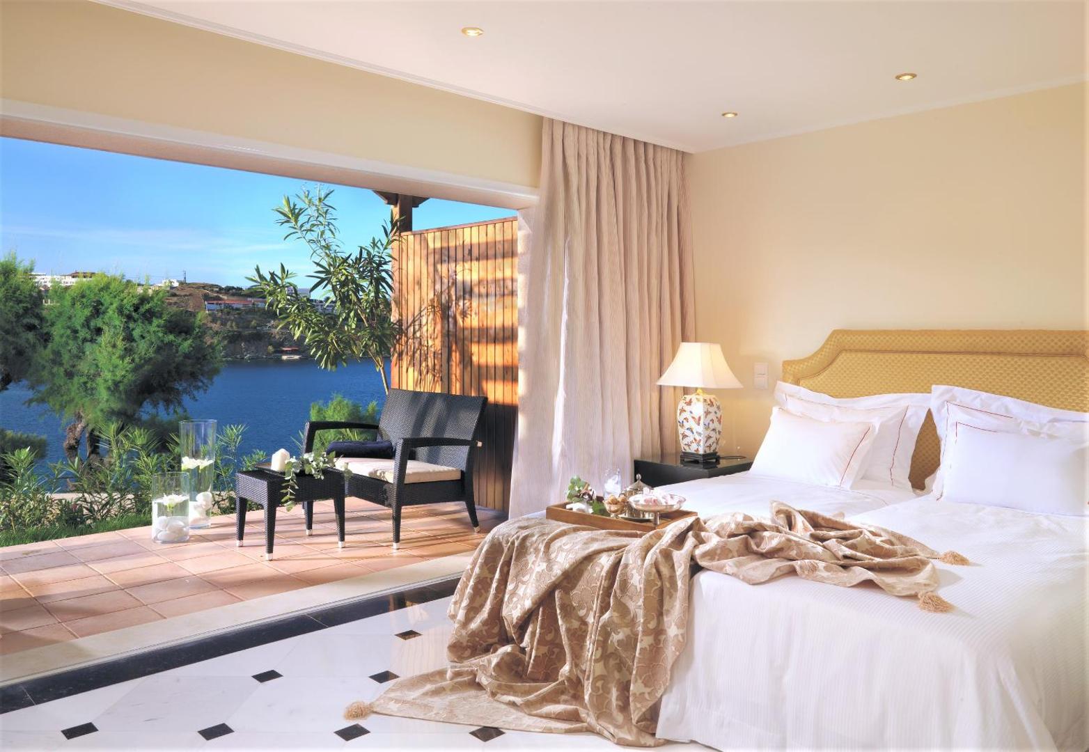 Out Of The Blue Resort & Spa gaišs numurs ar terasi un skatu uz jūru Krētā — atpūtas zona ar krēsliem un galdiņu
