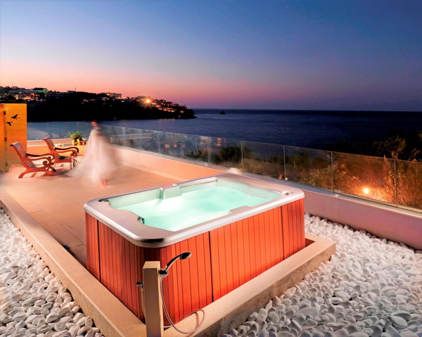 Out Of The Blue Resort & Spa privātā terase ar džakuzi saulrieta laikā — skats uz piekrasti un jūru Krētā