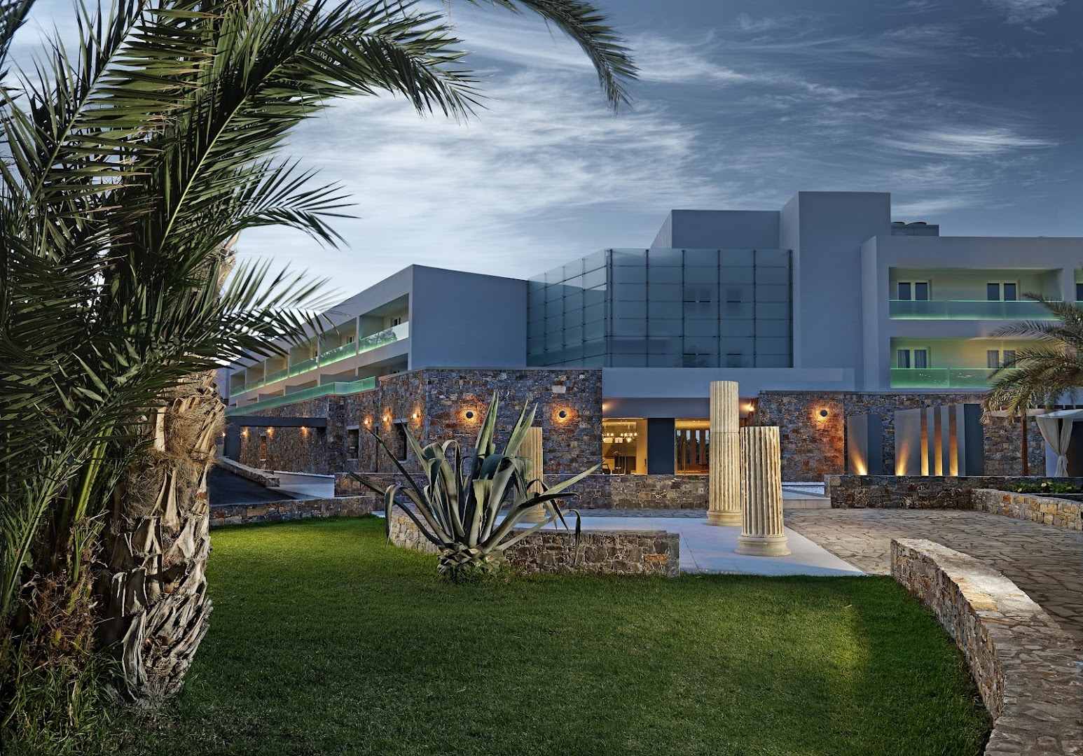 Out Of The Blue Resort & Spa modernā arhitektūra ar akmens mūra elementiem un antīkām kolonnām dārzā vakarā