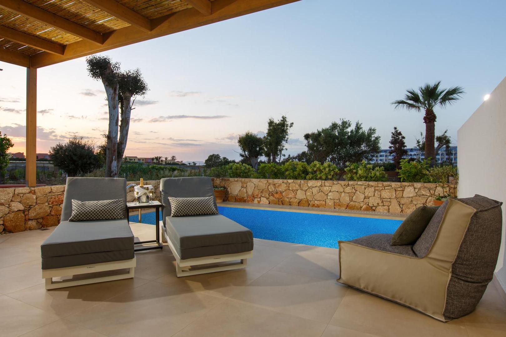 Aloe Boutique Hotel numurs ar tiešu piekļuvi baseinam, privātu terasi, sauļošanās krēsliem un skatu uz saulrietu Krētā