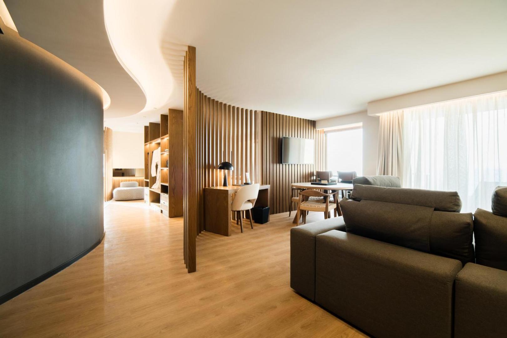 Akasha Beach Hotel & Spa plašs numurs ar koka apdari, atpūtas zonu, dīvānu un darba galdu mūsdienīgā stilā