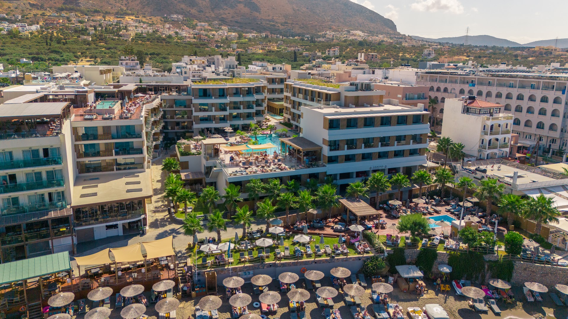 Akasha Beach Hotel & Spa modernā arhitektūra un teritorija Hersonisā — skats uz baseiniem, terasēm un apkārtējiem kalniem dienas laikā