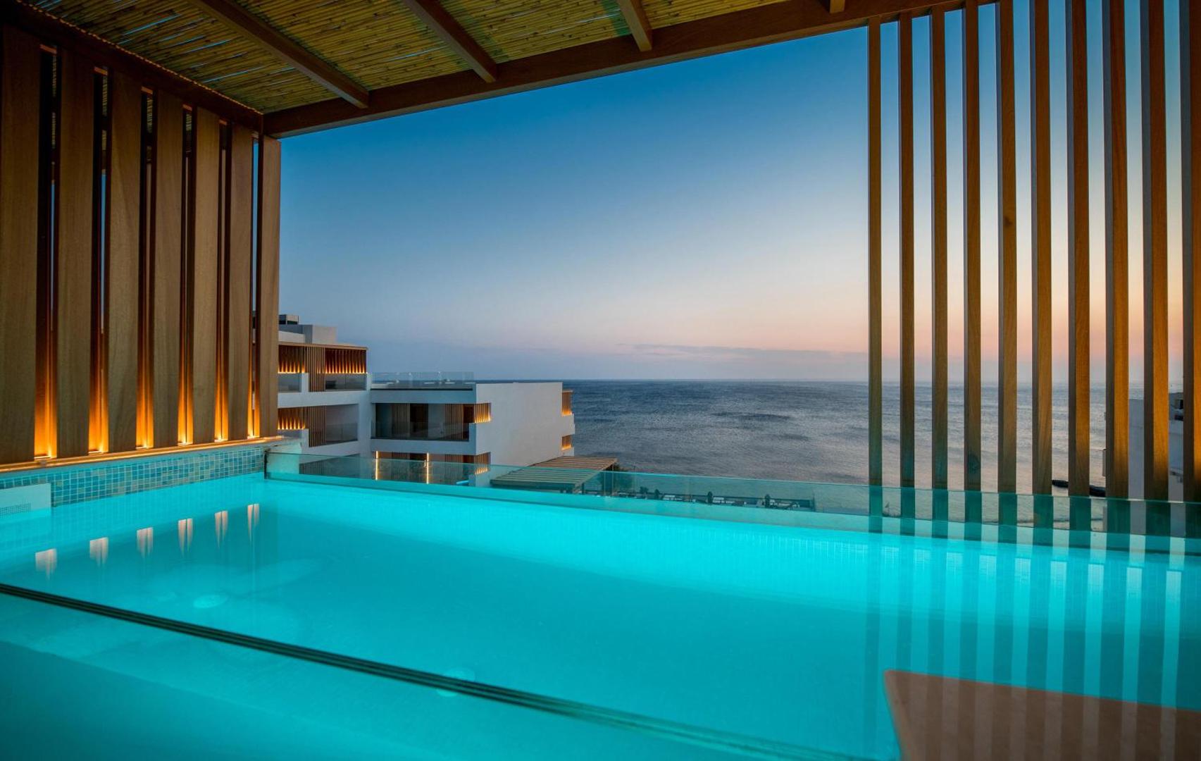 Akasha Beach Hotel & Spa numura terase ar privātu baseinu saulrietā Hersonisā, Krētā — skats uz jūru un modernu koka dizainu