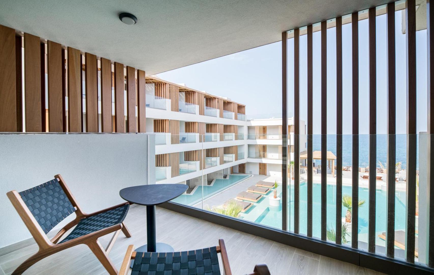 Skats no Akasha Beach Hotel & Spa numura balkona uz iekšpagalmu ar baseinu un viesnīcas korpusiem dienas laikā