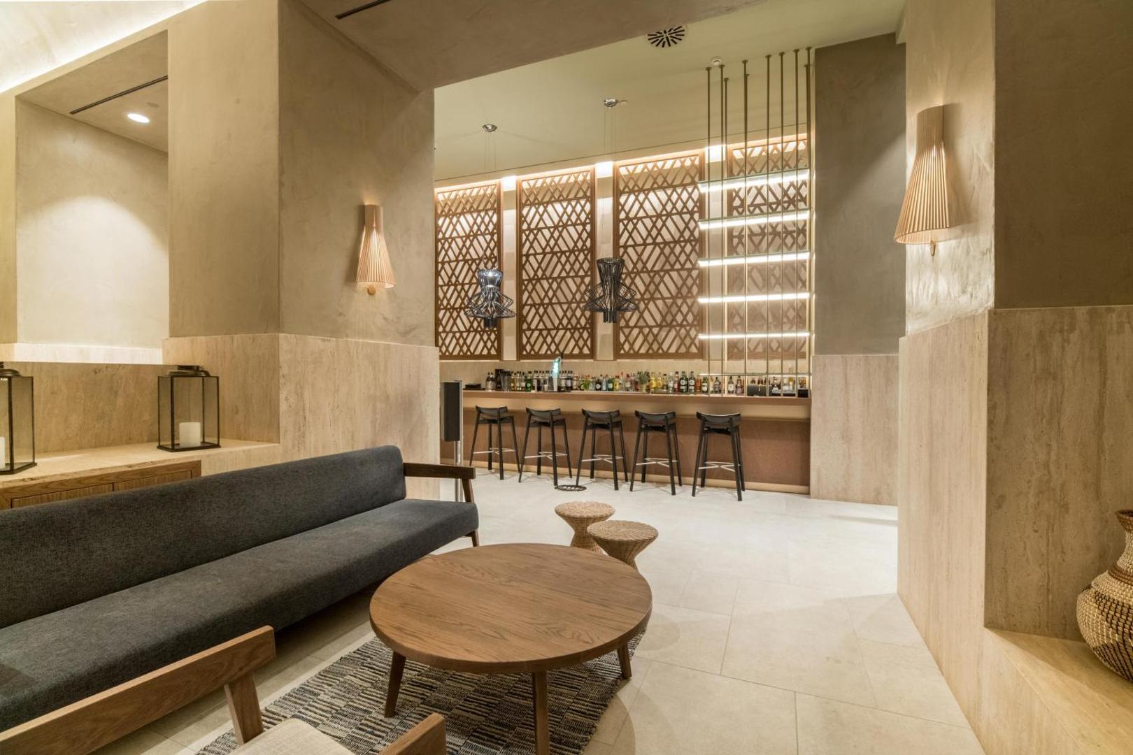 Akasha Beach Hotel & Spa stilīgais bārs un atpūtas telpa ar modernu apgaismojumu un dizaina elementiem