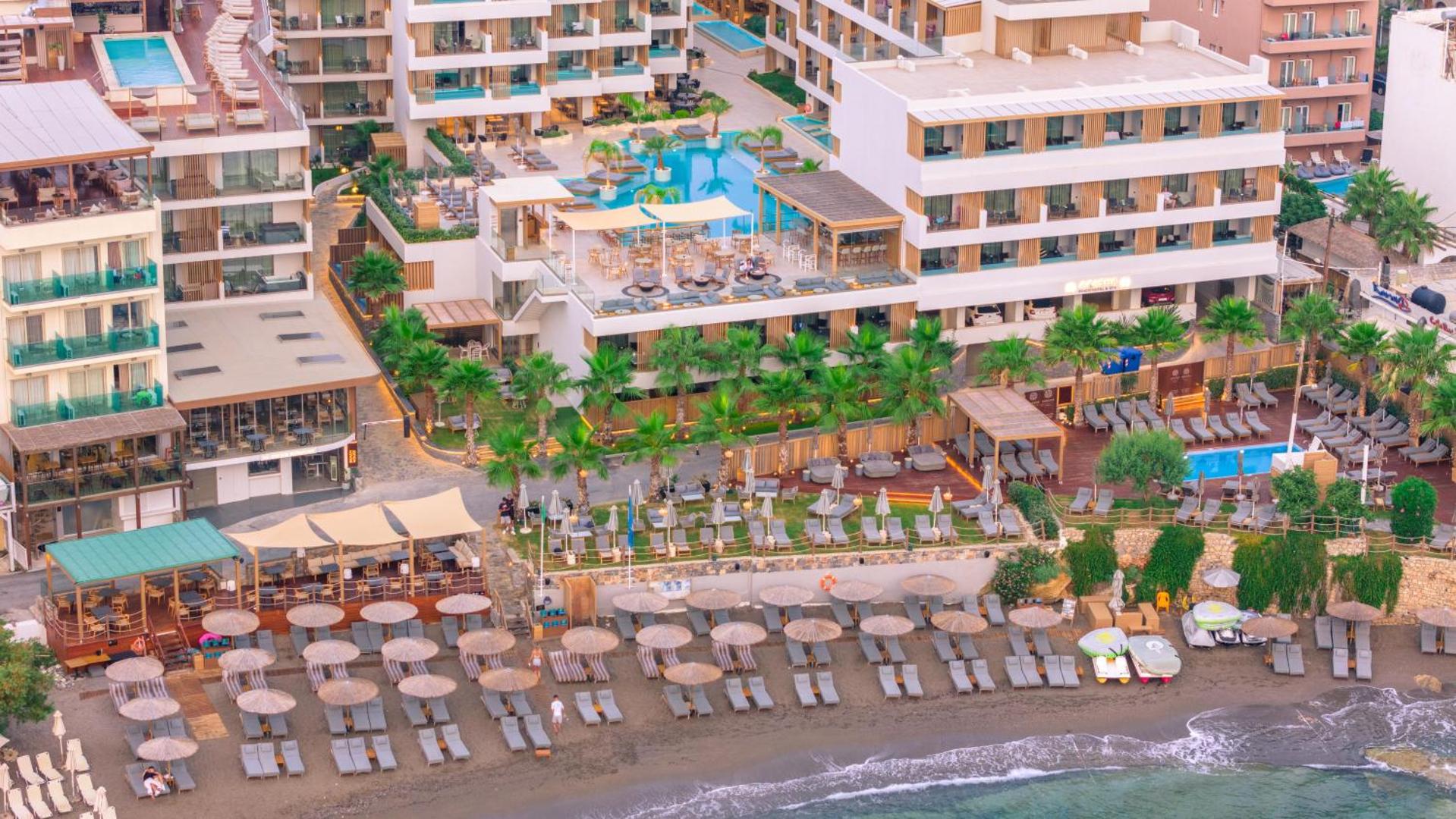 Akasha Beach Hotel & Spa skats uz galveno ēku, āra baseinu un pludmales zonu ar saulessargiem Hersonisas piekrastē, Krētā