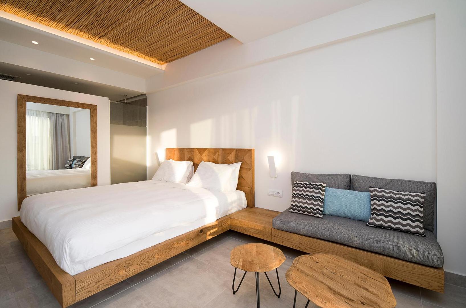 Viesnīcas Insula Alba Resort & Spa numura interjers ar koka elementiem, bambusa griestu apdari un ērtu atpūtas zonu.