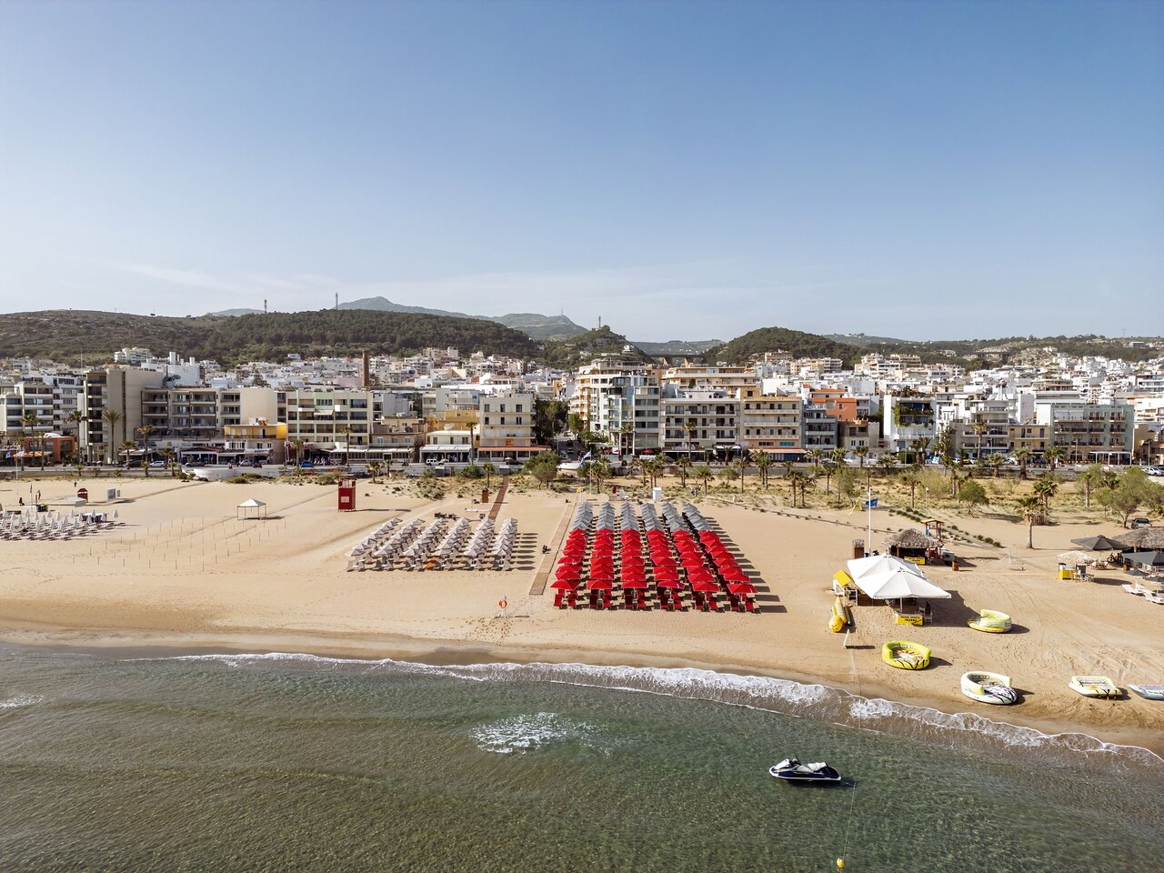 Kriti Beach Hotel atrašanās vieta Retimno piekrastē ar skatu uz pilsētas apbūvi, pludmali un kalniem fonā