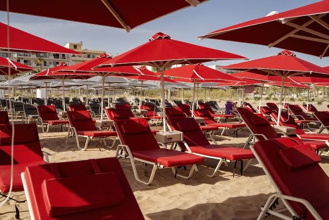 Sarkani saulessargi un ērti sauļošanās krēsli Kriti Beach Hotel smilšu pludmalē Retimno kūrortā