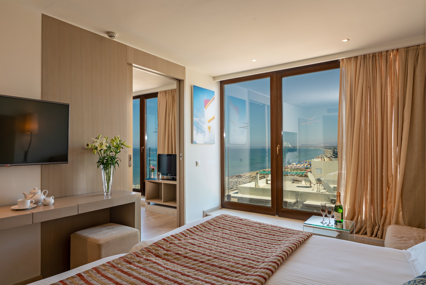 Kriti Beach Hotel gaišs numurs ar skatu uz jūru Retimno, Krētā — panorāmas logi, divguļamā gulta un atpūtas zona