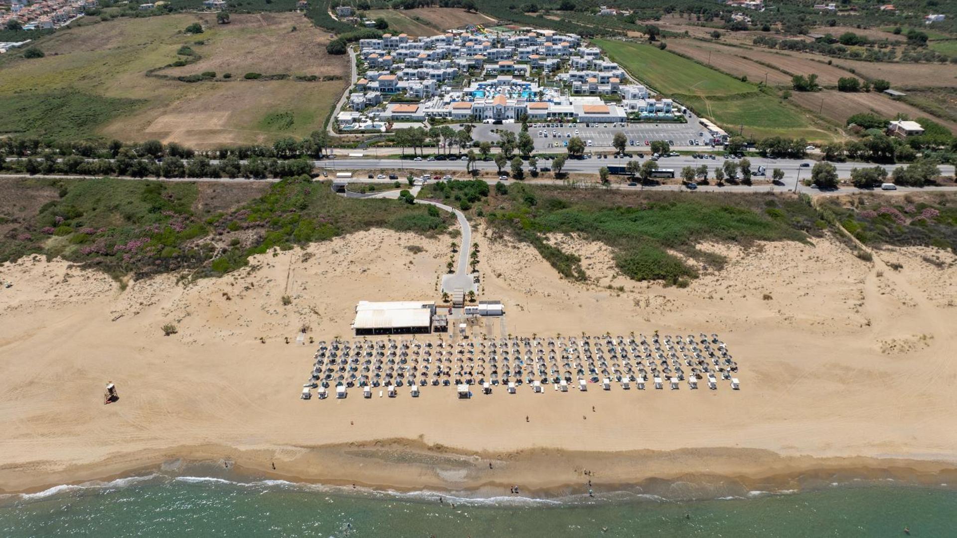 Anemos Luxury Grand Resort teritorijas un pludmales aerofoto skats, parādot viesnīcas kompleksu un pieeju jūrai