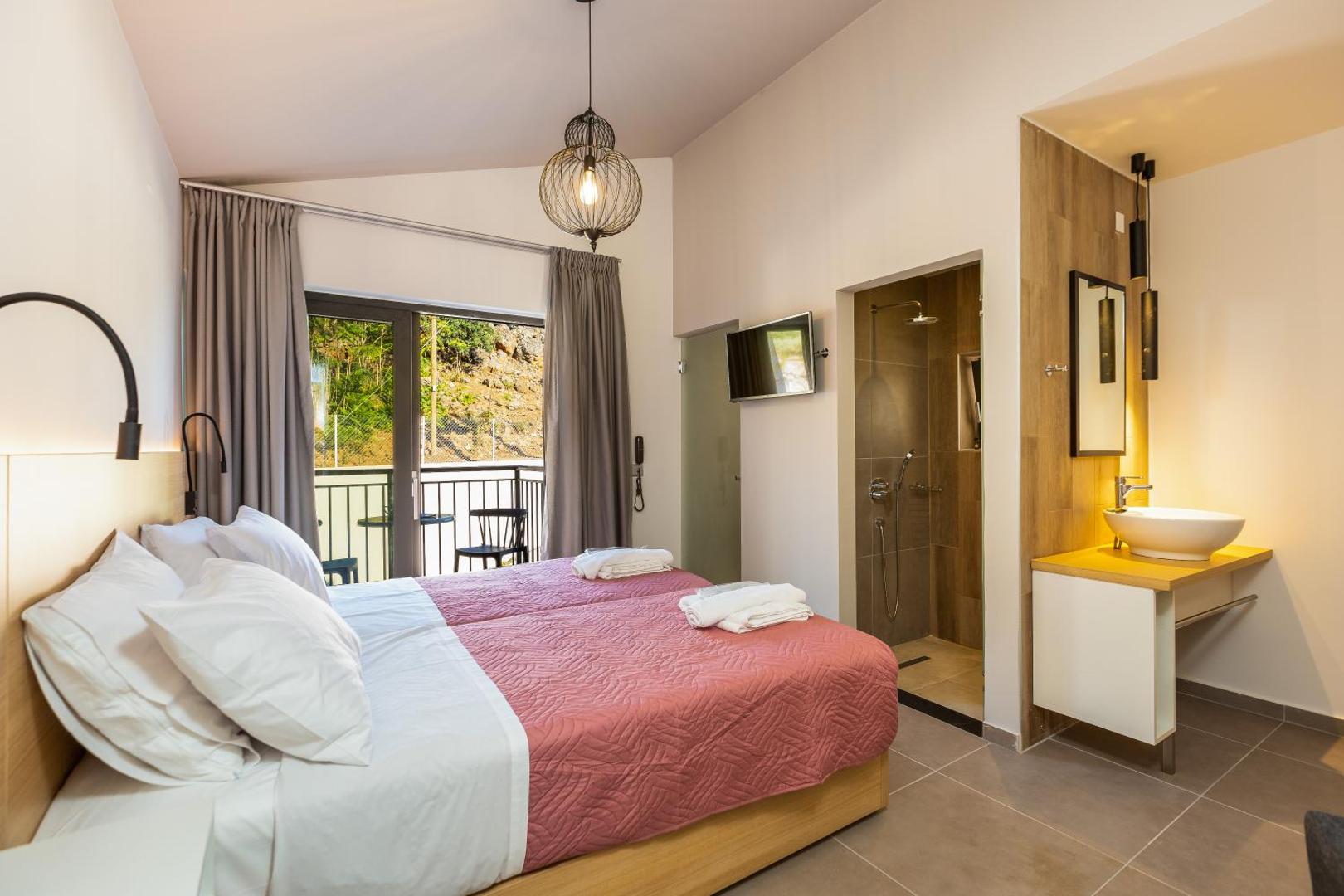 Gaišs T Hotel Premium Suites viesnīcas numurs ar balkonu, divguļamo gultu un integrētu vannas istabas zonu Bali, Krētā