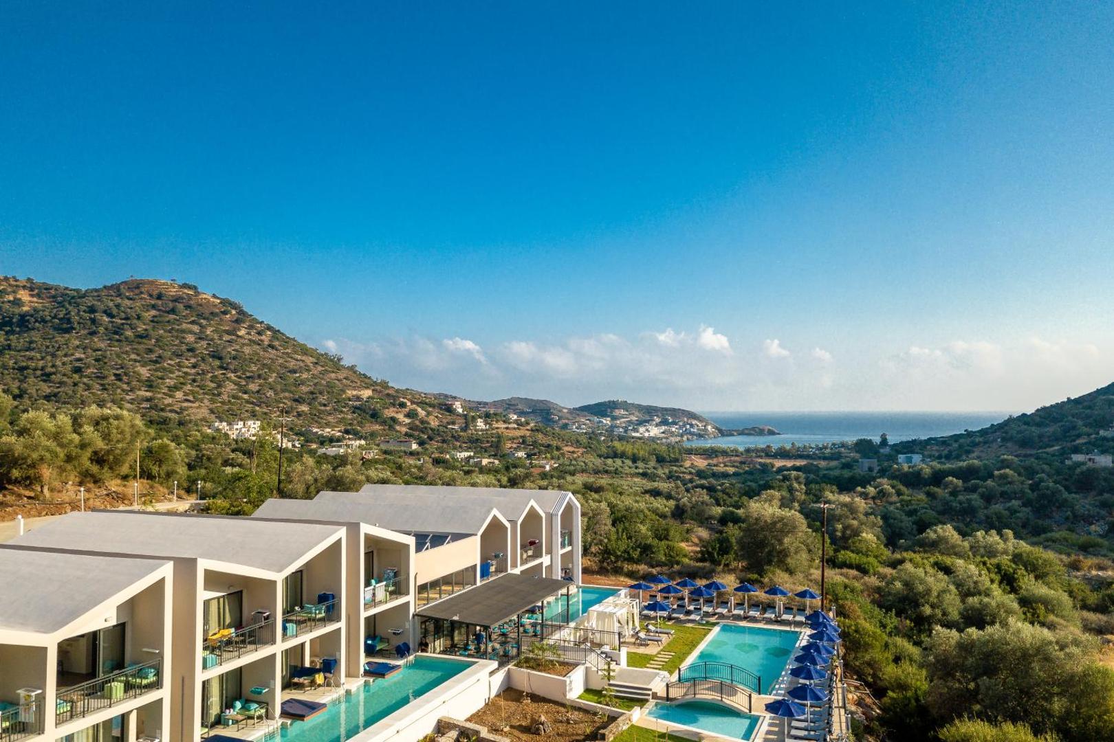 T Hotel Premium Suites panorāmas skats no putna lidojuma uz viesnīcas kompleksu, baseiniem un apkārtējiem kalniem Bali, Krētā