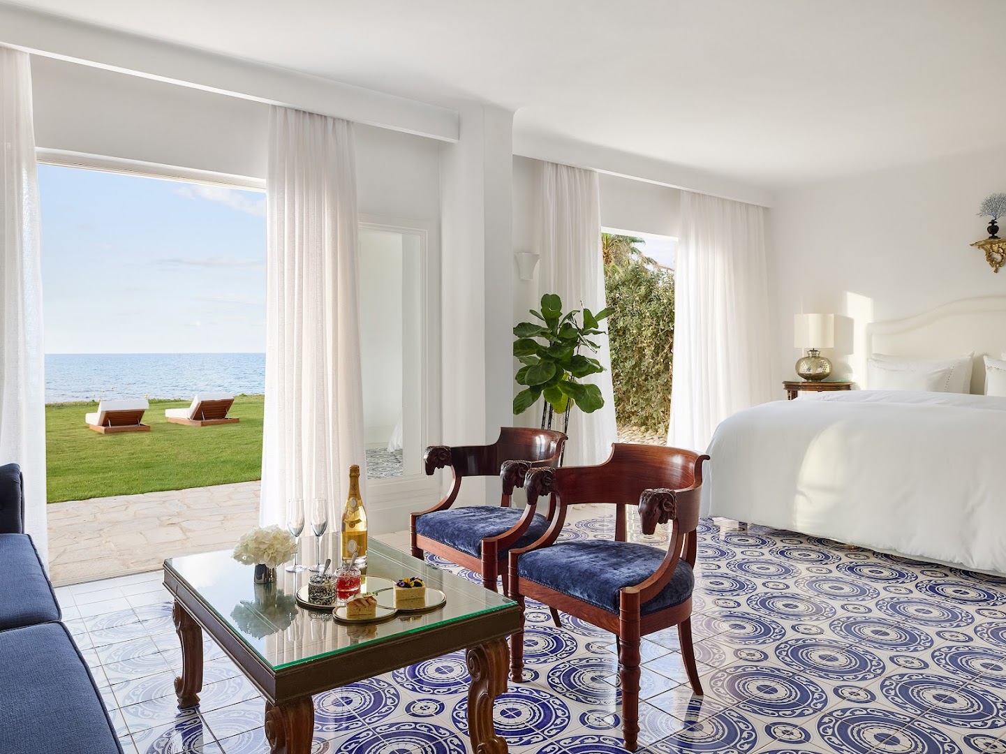 Caramel Grecotel Resort luksusa numurs ar greznām flīzēm, atpūtas zonu un skatu uz dārzu un jūru Krētā