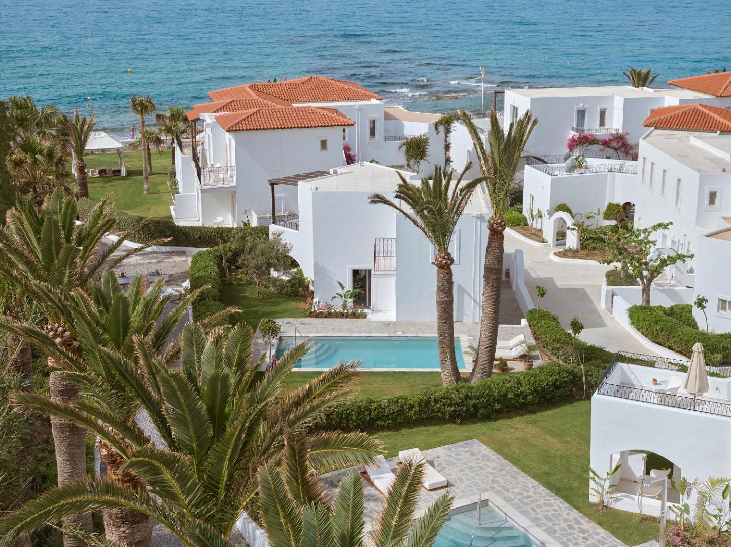 Caramel Grecotel Resort balti bungalo un privātie baseini dārza zonā pie jūras Krētā — skats no augšas uz kūrorta teritoriju
