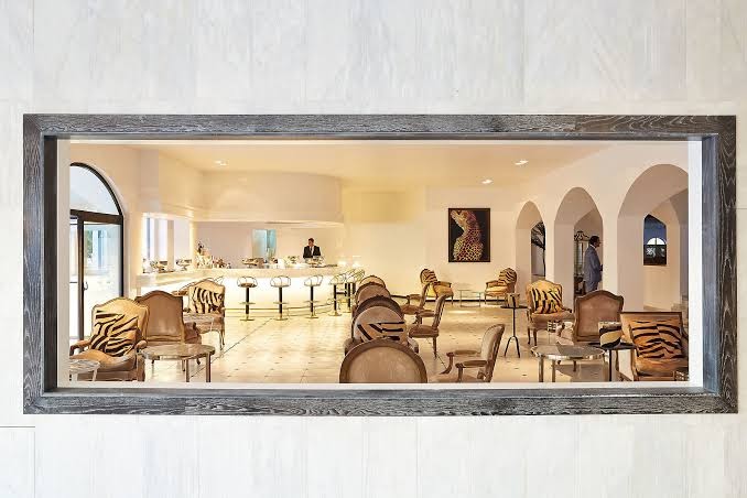 Caramel Grecotel Boutique Resort lobby bārs ar stilīgiem atpūtas krēsliem un arkveida ejām Krētas piekrastē