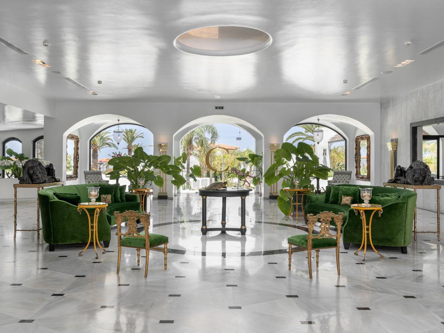 Caramel, Grecotel Boutique Resort greznais lobby ar marmora grīdām, zaļiem samta dīvāniem un skatu uz dārzu Retimno, Krētā