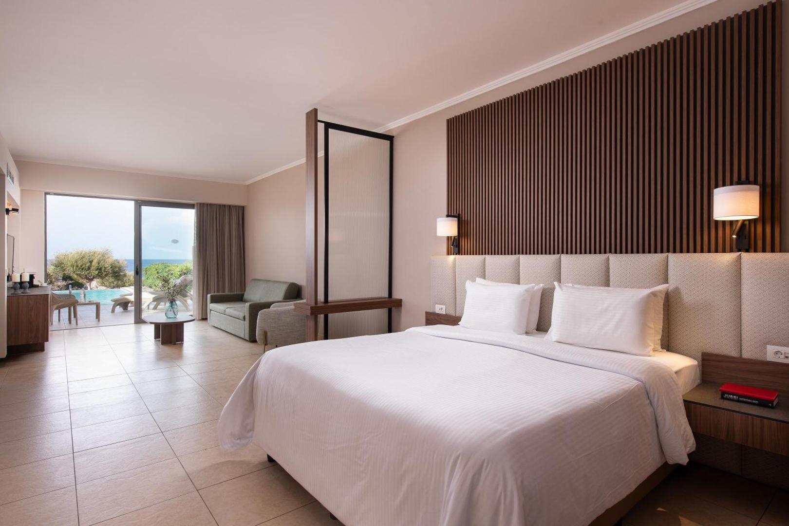 Kresten Royal Euphoria Resort plašs numurs ar divguļamo gultu, atpūtas zonu un skatu uz baseinu Rodas salā, Grieķijā.
