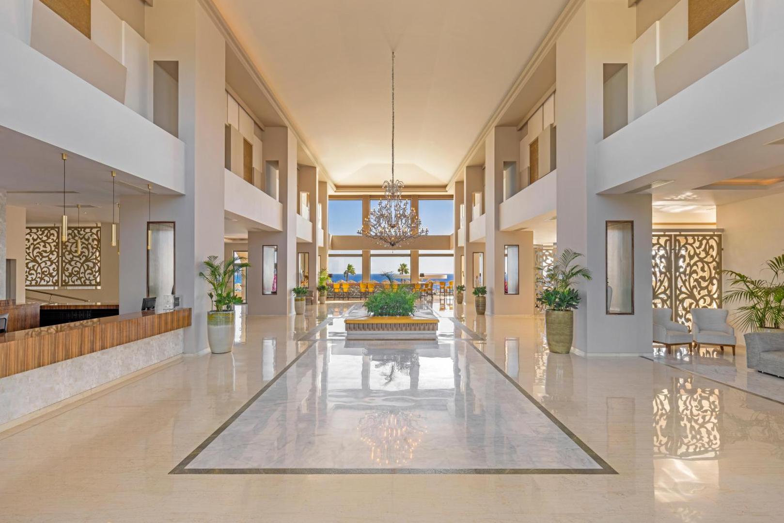 Kresten Royal Euphoria Resort plašais un gaišais vestibils Rodas salā ar marmora grīdām, augstiem griestiem un skatu uz jūru