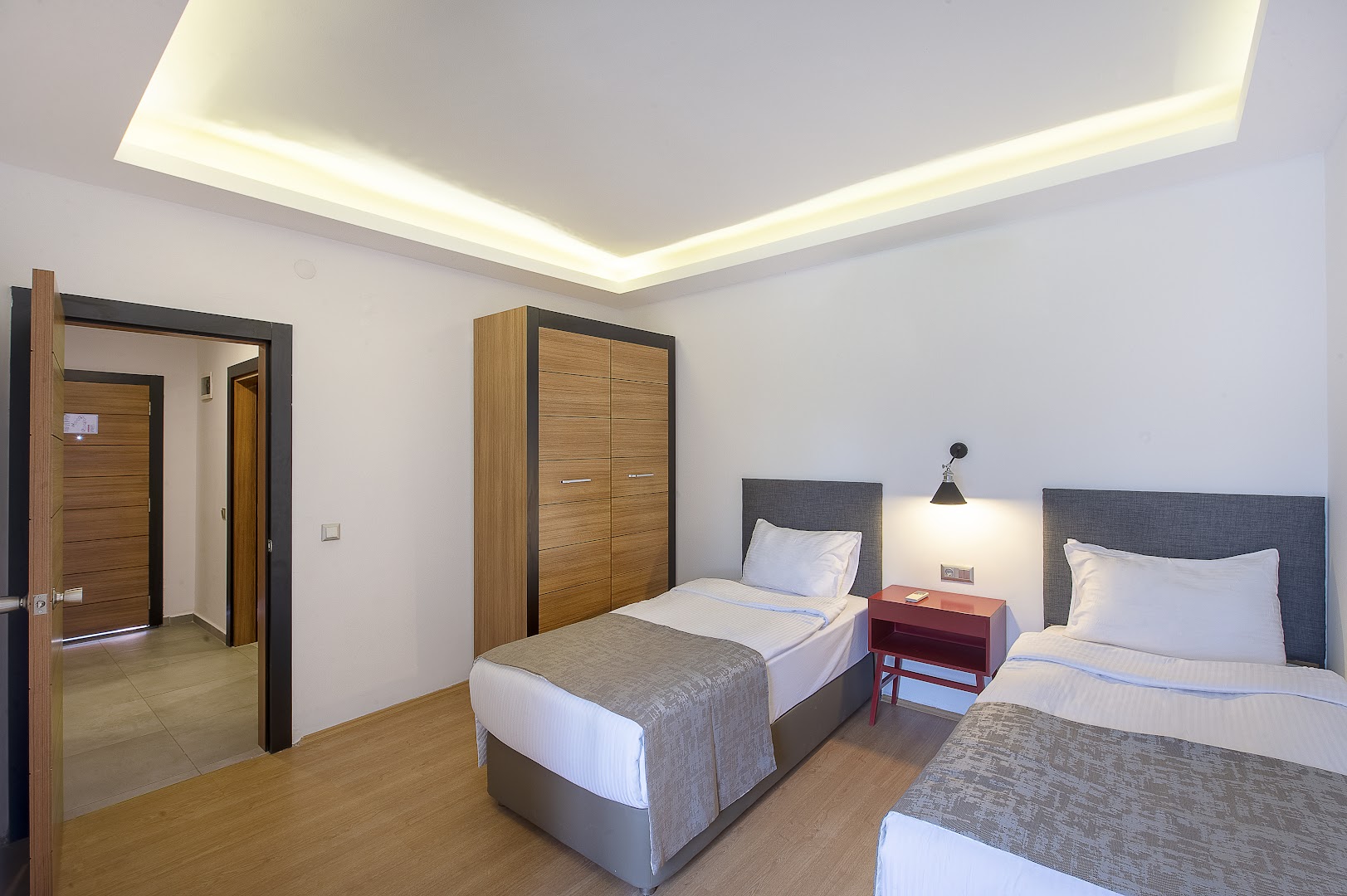 Utopia Resort & Residence numurs ar divām atsevišķām gultām, koka skapi un modernu apgaismojumu gaišos toņos Alānijā
