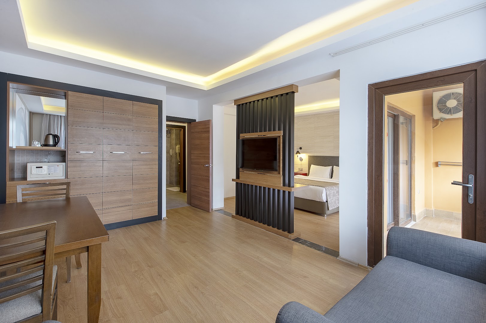 Utopia Resort & Residence ģimenes numura dzīvojamā zona ar dīvānu, ēdamgaldu un skatu uz guļamistabu caur dekoratīvu starpsienu
